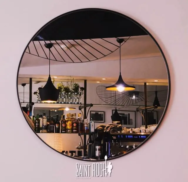 Le miroir rond et le bar de la salle